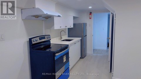 A brokerage kitchen with a blue stove and white cabinets.