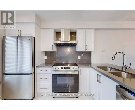 A modern kitchen with white cabinets and stainless steel appliances.