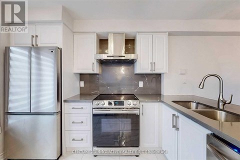 A modern kitchen with white cabinets and stainless steel appliances.