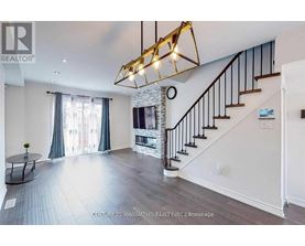 A spacious living room with a staircase and a fireplace.