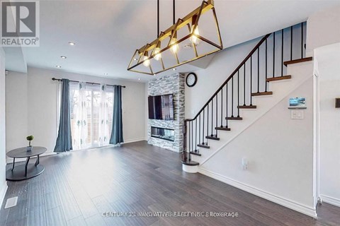 A spacious living room with a staircase and a fireplace.