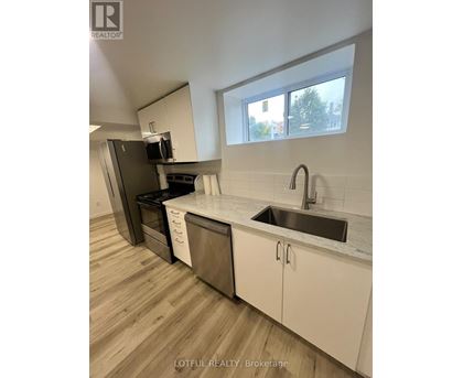 A kitchen with a sink, stove, and cabinets.