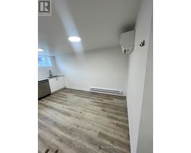 A room with wooden flooring and white walls.