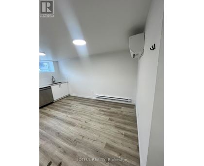 A room with wooden flooring and white walls.
