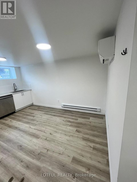 A room with wooden flooring and white walls.