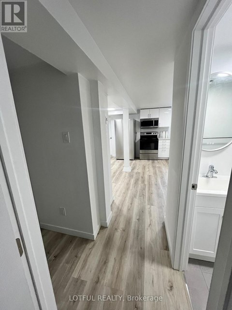 A hallway with wood flooring and white walls.