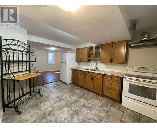 A kitchen with a white stove top oven and wooden cabinets.