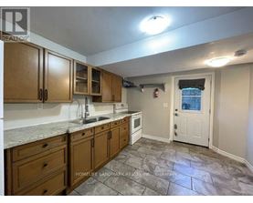 A kitchen with wooden cabinets and a stone floor.
