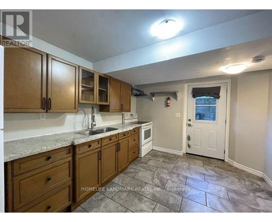 A kitchen with wooden cabinets and a stone floor.