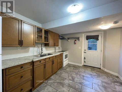 A kitchen with wooden cabinets and a stone floor.