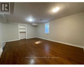 A room with wooden flooring and a window.
