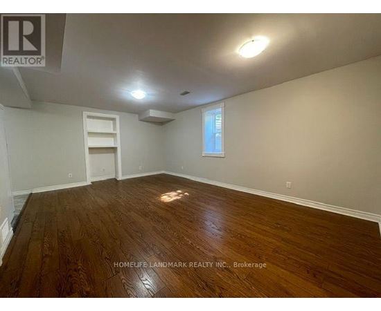 A room with wooden flooring and a window.