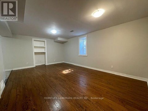 A room with wooden flooring and a window.