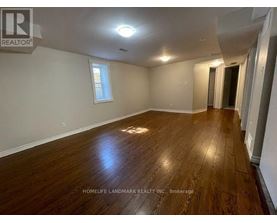 A room with wooden flooring and a window is for sale.