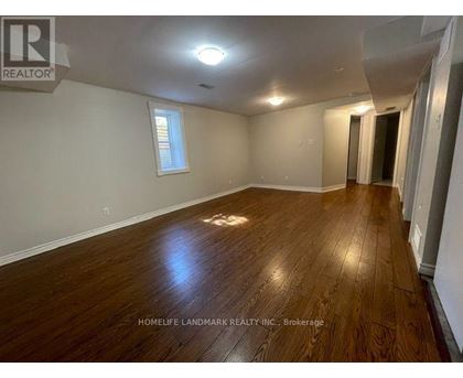 A room with wooden flooring and a window is for sale.