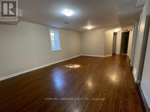 A room with wooden flooring and a window is for sale.