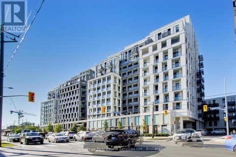 A large building with many windows is in the background of a busy street.