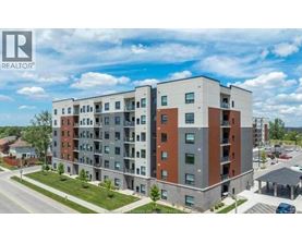 A large apartment building with a parking lot in front.