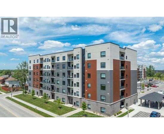 A large apartment building with a parking lot in front.