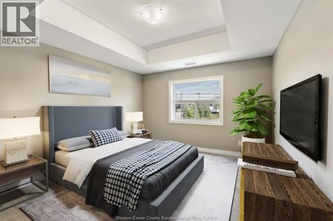 A bedroom with a large bed and a television on the wall.