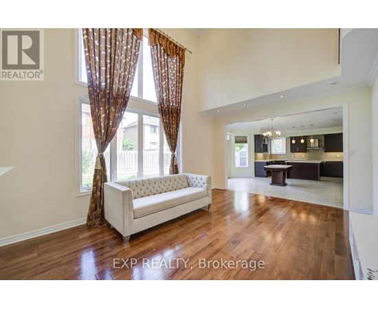 A living room with a white sofa and wooden floors.