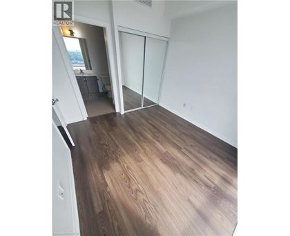 A room with wood flooring and a sliding glass door.