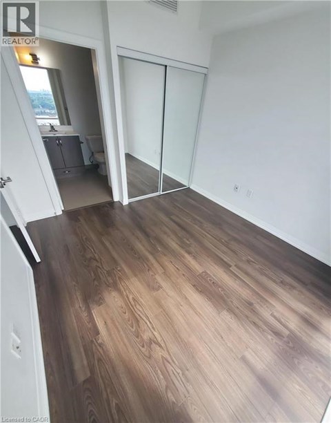 A room with wood flooring and a sliding glass door.