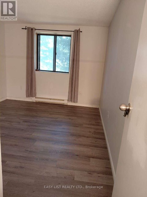 A room with a window and wooden flooring.