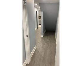 A hallway with a white door and a grey floor.