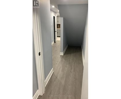A hallway with a white door and a grey floor.
