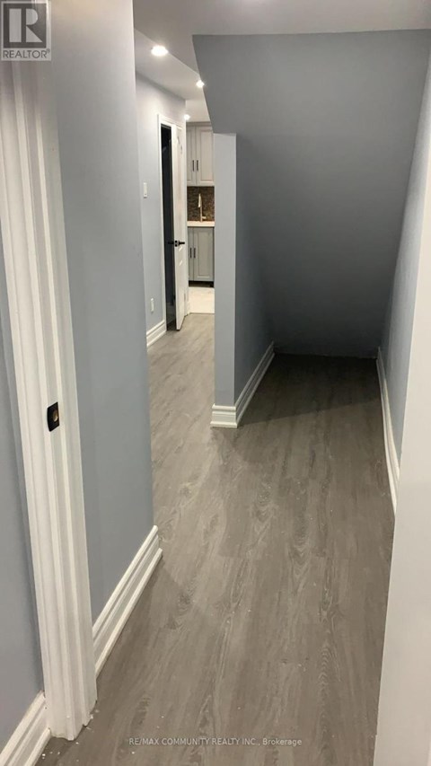 A hallway with a white door and a grey floor.