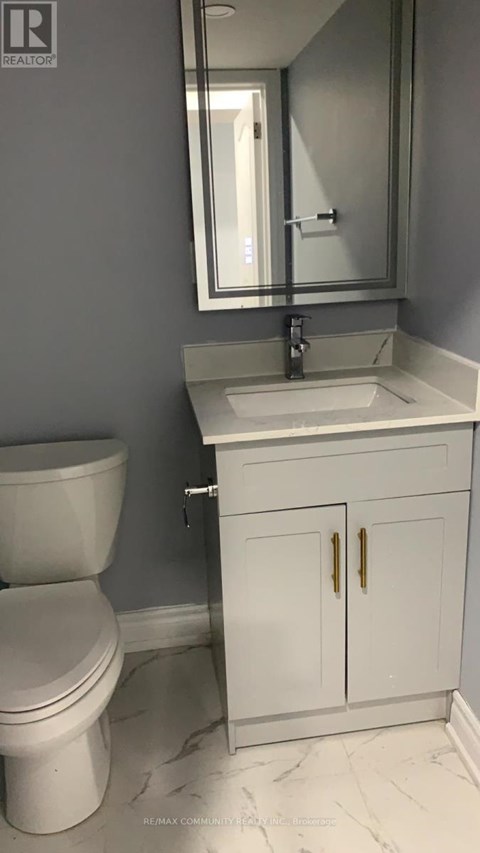 A white toilet sits next to a sink in a bathroom.