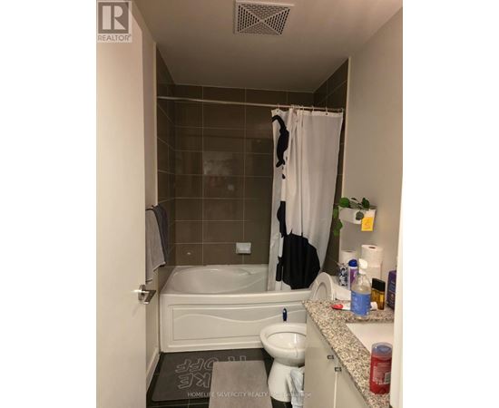 A bathroom with a white tub, sink, and shower curtain.