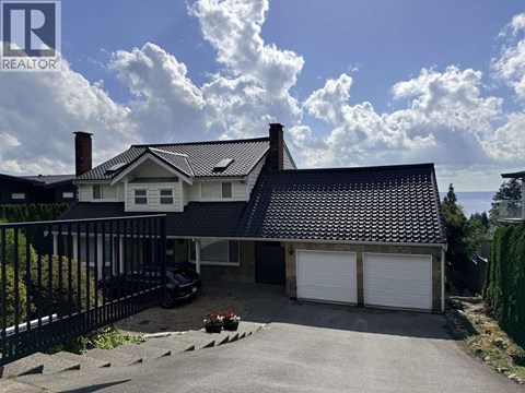 A house with a black fence and a car parked in front.
