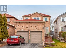 A red car is parked in front of a brick house with a garage.