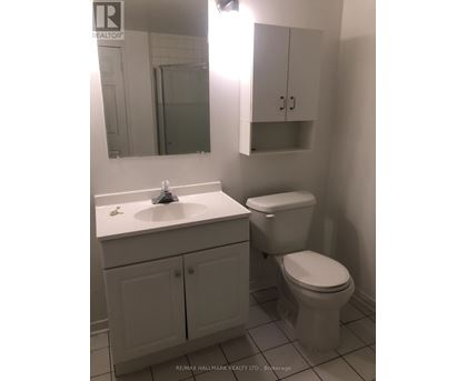 A white bathroom with a toilet, sink and medicine cabinet.