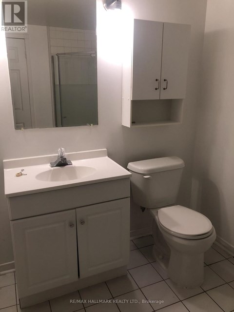 A white bathroom with a toilet, sink and medicine cabinet.