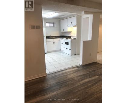 A kitchen with white cabinets and a black countertop.