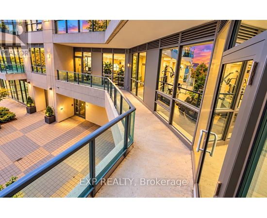 A modern building with a glass balcony and a tiled floor.