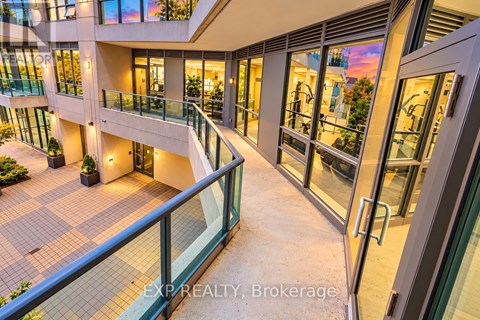 A modern building with a glass balcony and a tiled floor.
