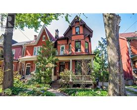 A Victorian style house with a red roof and a porch.