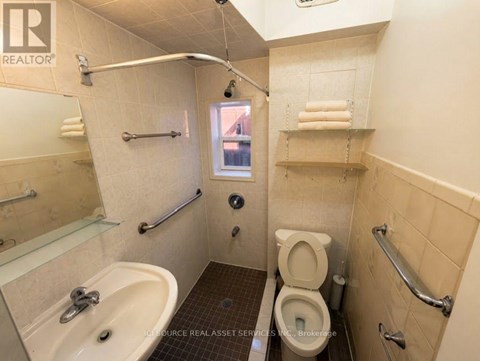 A bathroom with a toilet, sink, and shower.