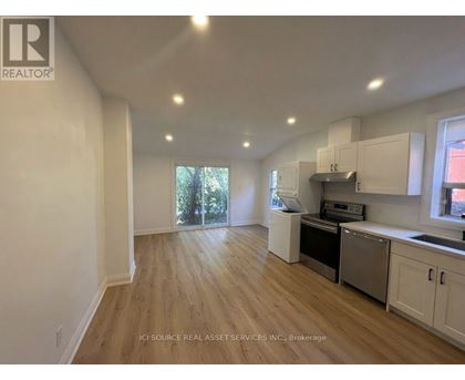 A kitchen with white cabinets and a wooden floor.