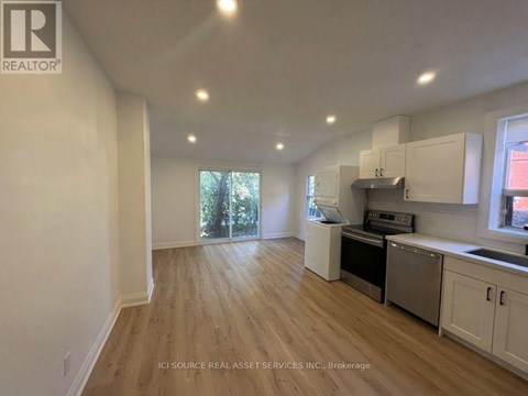 A kitchen with white cabinets and a wooden floor.
