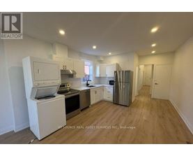 A kitchen with white appliances and wooden floors.