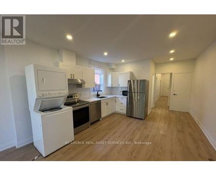 A kitchen with white appliances and wooden floors.