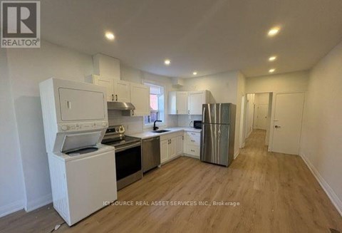 A kitchen with white appliances and wooden floors.