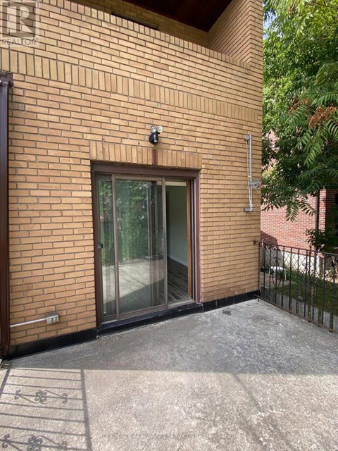 A brick building with a glass door and a small camera on the wall.