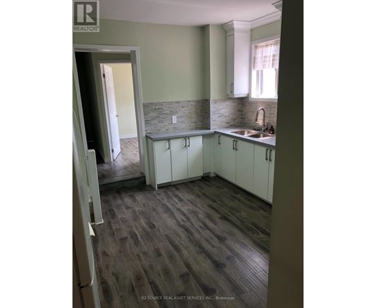 A kitchen with white cabinets and a stone backsplash.