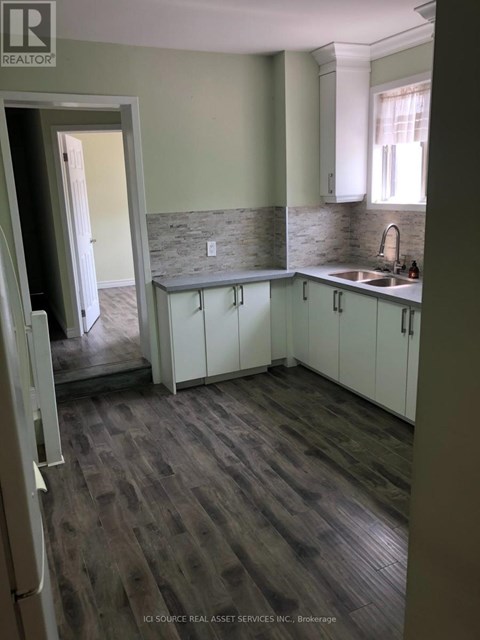 A kitchen with white cabinets and a stone backsplash.